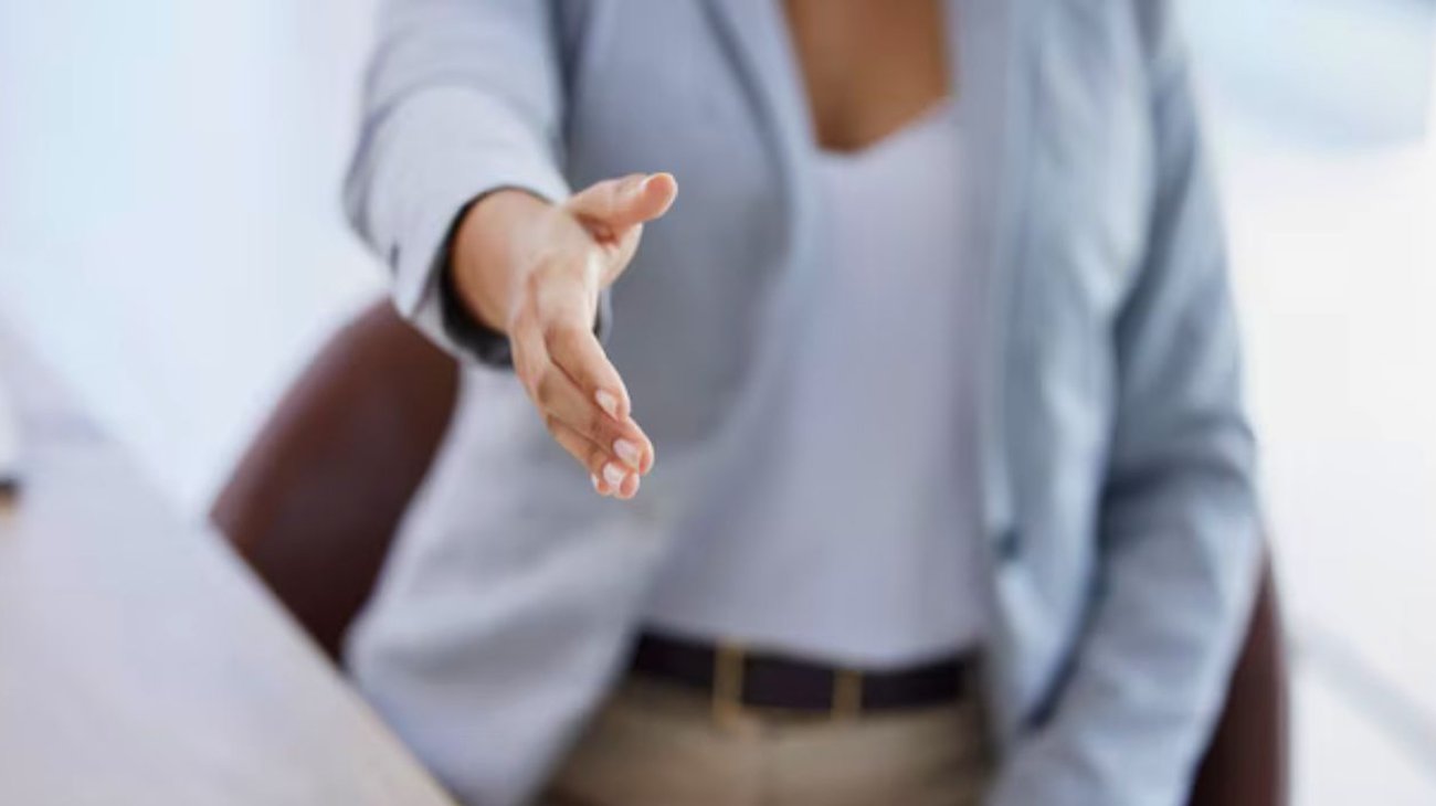 Joven gana demanda tras despido por no dar la mano a colega