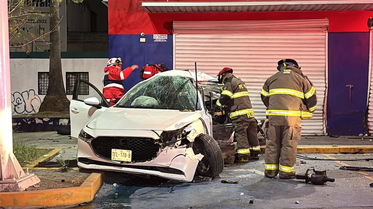 Quedan 2 jóvenes atrapados en auto tras estrellarse contra poste