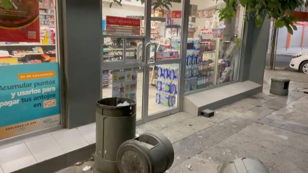 Destroza con botes de basura puerta de cristal en tienda