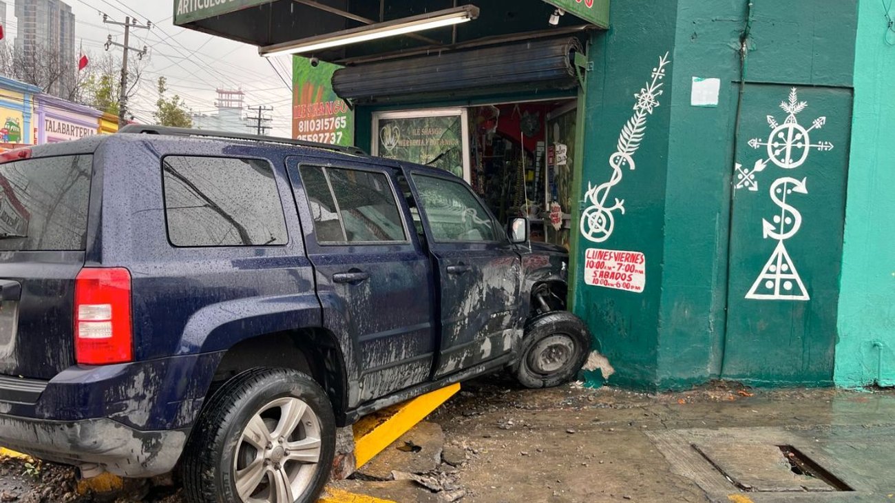 Se pasa alto, choca contra auto y se estrella en un negocio