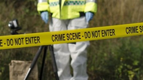 21892624_detective_buscando_pruebas_detras_de_una_barrera_de_la_escena_del_crimen_95f13c000f