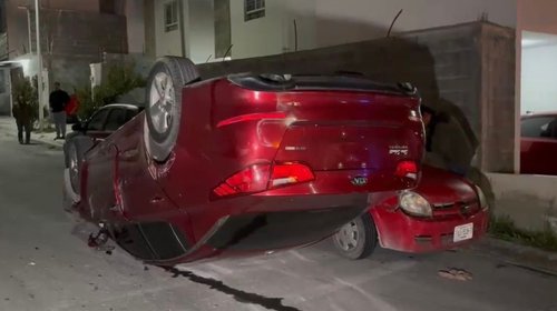 Choca con autos estacionados y termina volcado